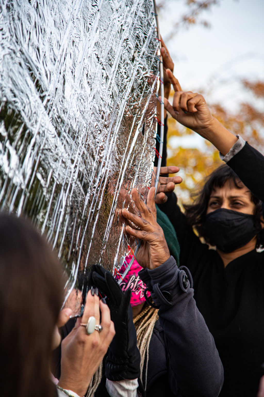 close up photo of a small group of people holding up a large silver disc