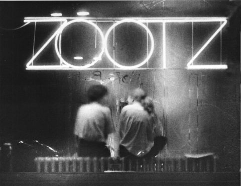 A black and white photograph of Zootz with the original neon sign against a steamy window in 1989