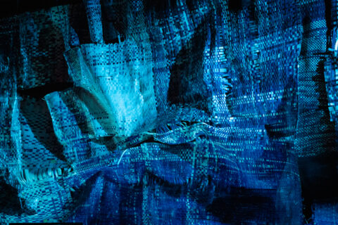James Allister Sprang installation still of Aquifer of the Weave, 2022, 37 by 17 ft. cyanotype weaving, kinetic light, original score and 4DSound