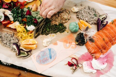 Jenny Ibsen's Fish Picnic invitation, stained by surrounding foods on a long table
