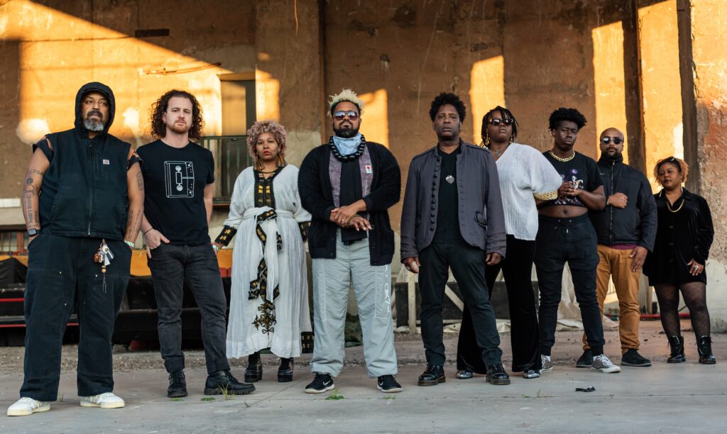 The full 9-piece Mourning a Black Star band standing shoulder to shoulder looking impossibly cool. 