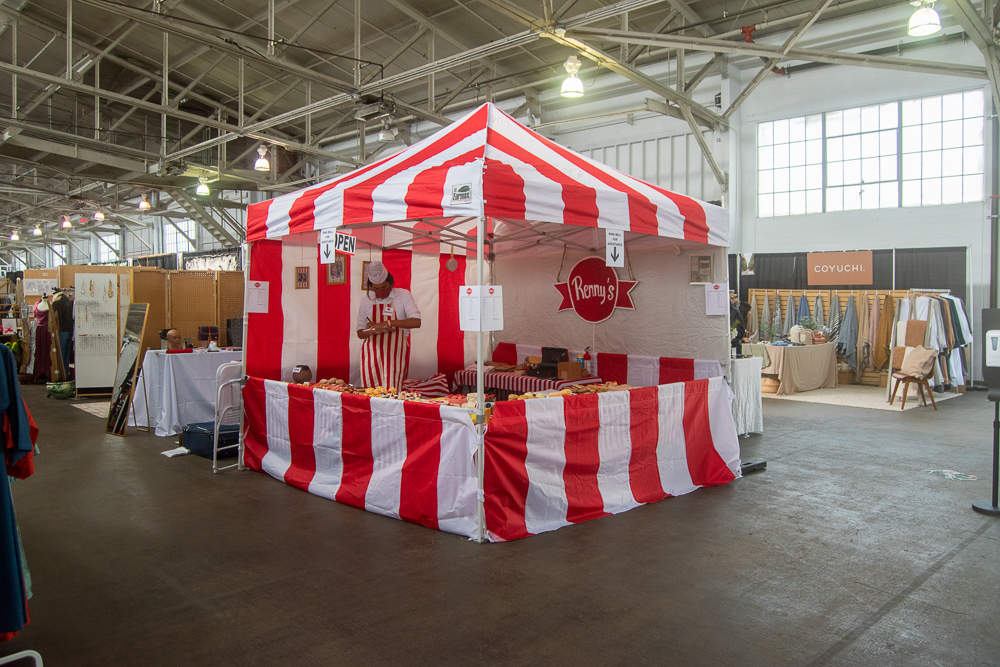 large red and white striped vendor tent in a convention space