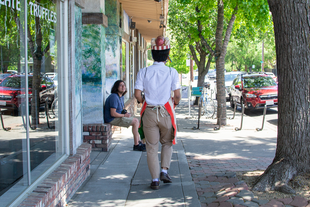 image of the back of a man walking down a city sidewalk