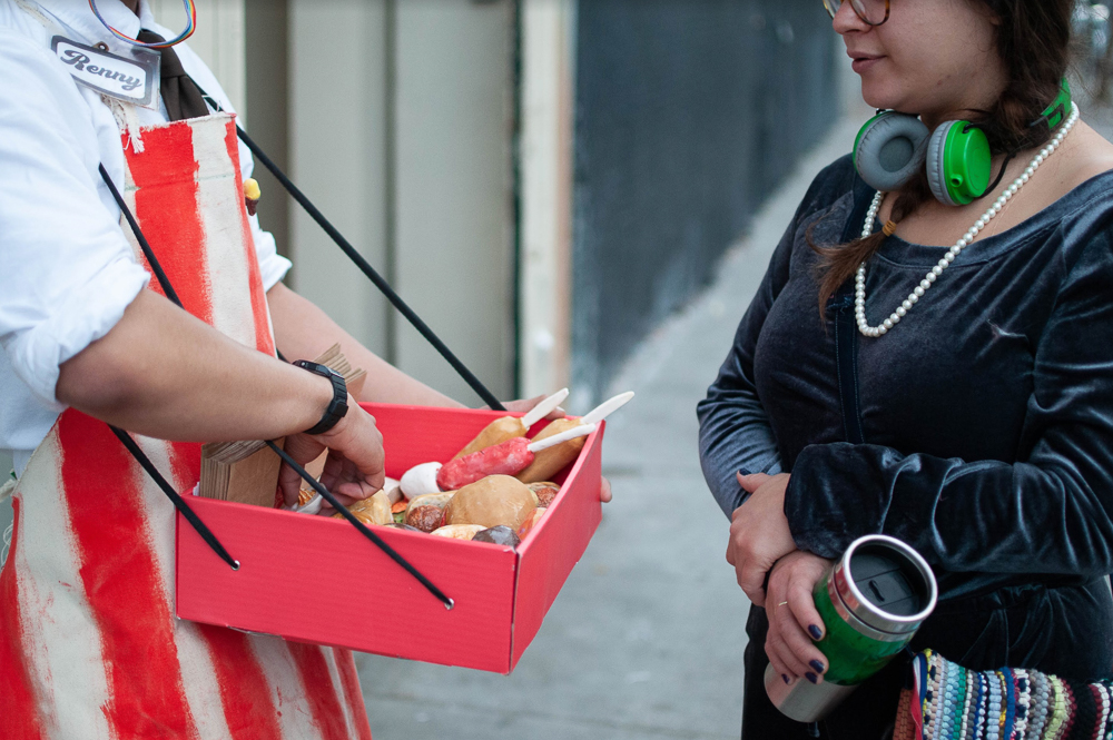 Reniel in front of a gallery selling ceramic food to passersby going in and out of the space