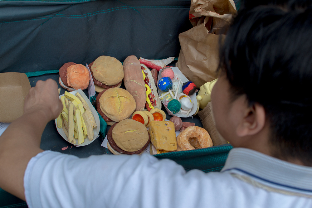 man reaching into a container of ceramic food