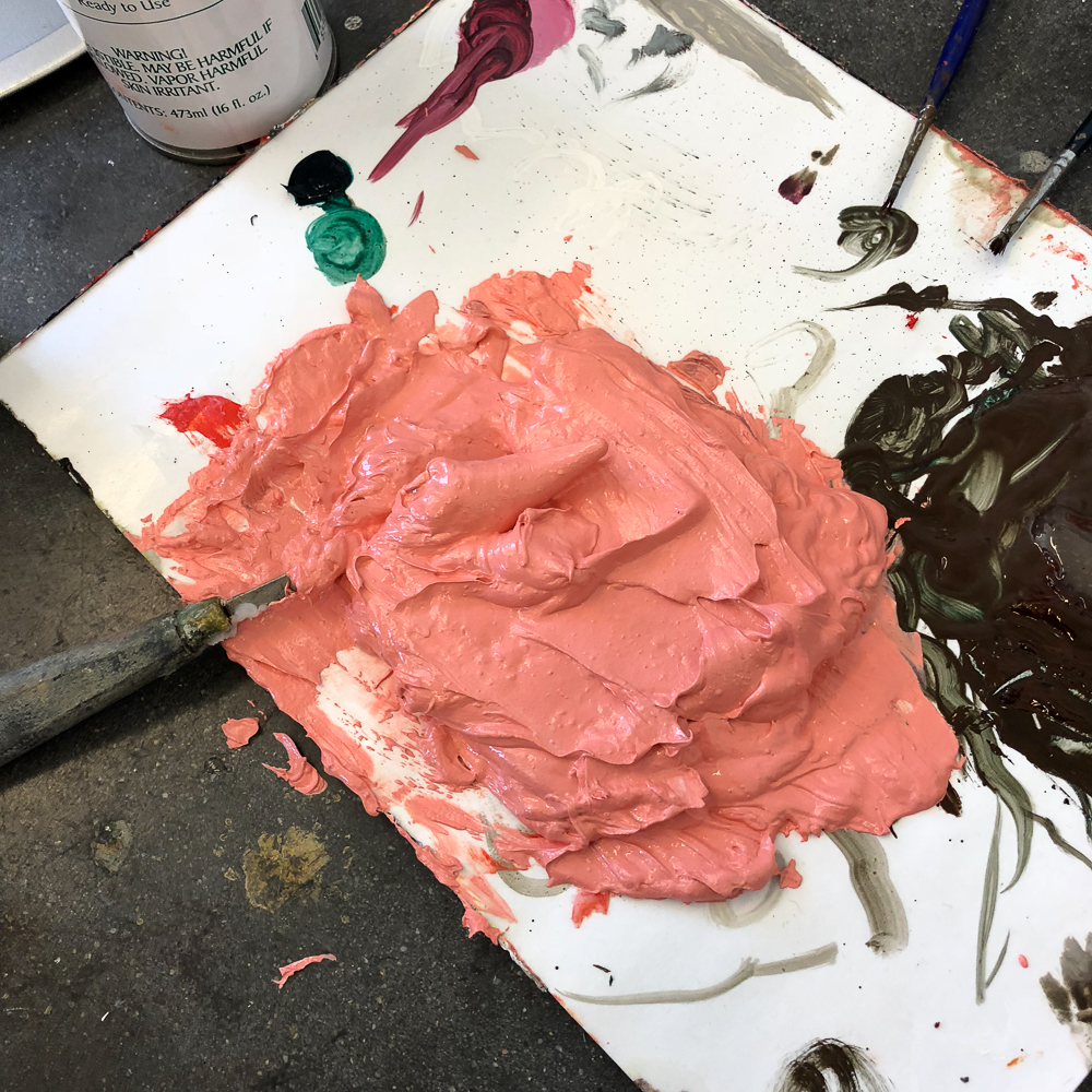 palette covered in thick brown and salmon paints