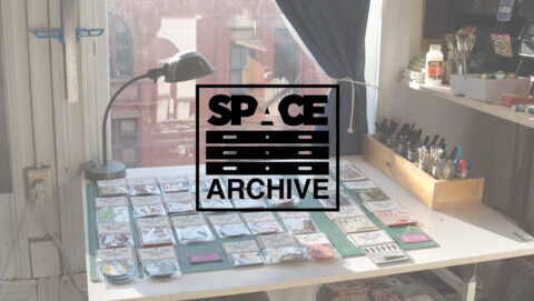 image of a table covered in fabric patches with the words 'space archive' on a digital overlay