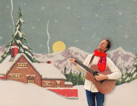 A faux retro holiday card with a snow covered cabin and mountains, with a photograph of Jesse Hale Moore singing with his guitar photoshopped in.
