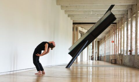 a photography of a woman dancing in the halls of the Mass MoCA art gallery in Western Massachusetts
