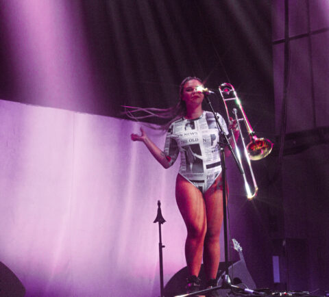 The singer and multi-instrumentalist artist Viva holds a trombone on stage