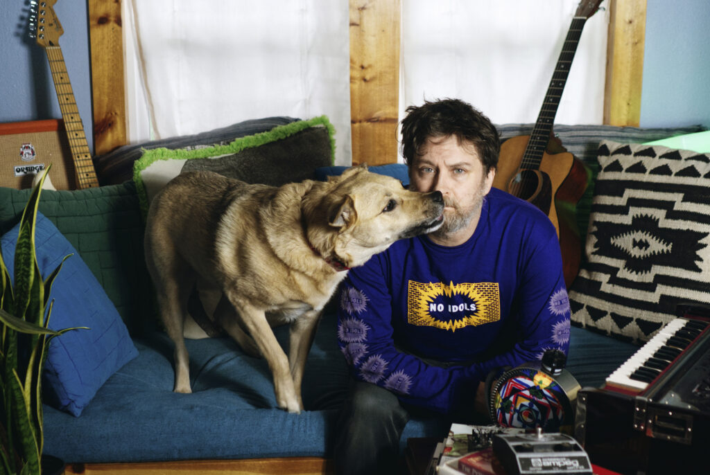 Ben Chasny aka Six Organs of Admittance sitting on a couch with his dog standing on the same couch and cutely sniffing over at Ben's face.