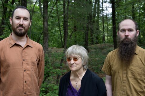 Jazz musicians Brian Shankar Adler, Jane Ira Bloom, and Mike Effenberger stand in the woods looking at the camera (Photo by Jake Sartorius)