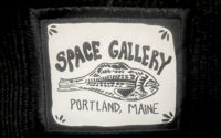 A black and white patch hand drawn that says "SPACE Galley, Portland, Maine" with a drawing of a fish.