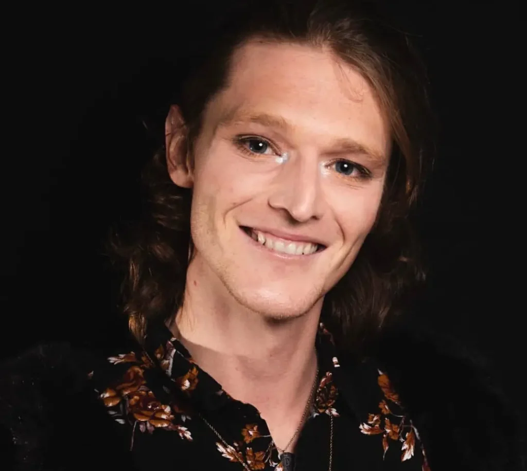 A headshot of local comedian Danny Jordan smiling sweetly and looking into the camera