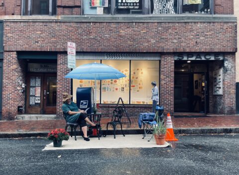 Linda Shary of Guerrilla Downtown sits in a parking spot outside SPACE on September 20, 2024, for her project FREE CONVERSATIONS, part of Portland Downtown's Park(ing) Day 2024