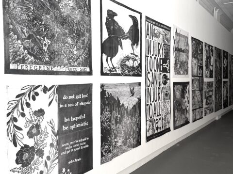 An installation photograph of the large scale black and white prints on fabric from the Print Jam with various animals, flowers, and words on them.